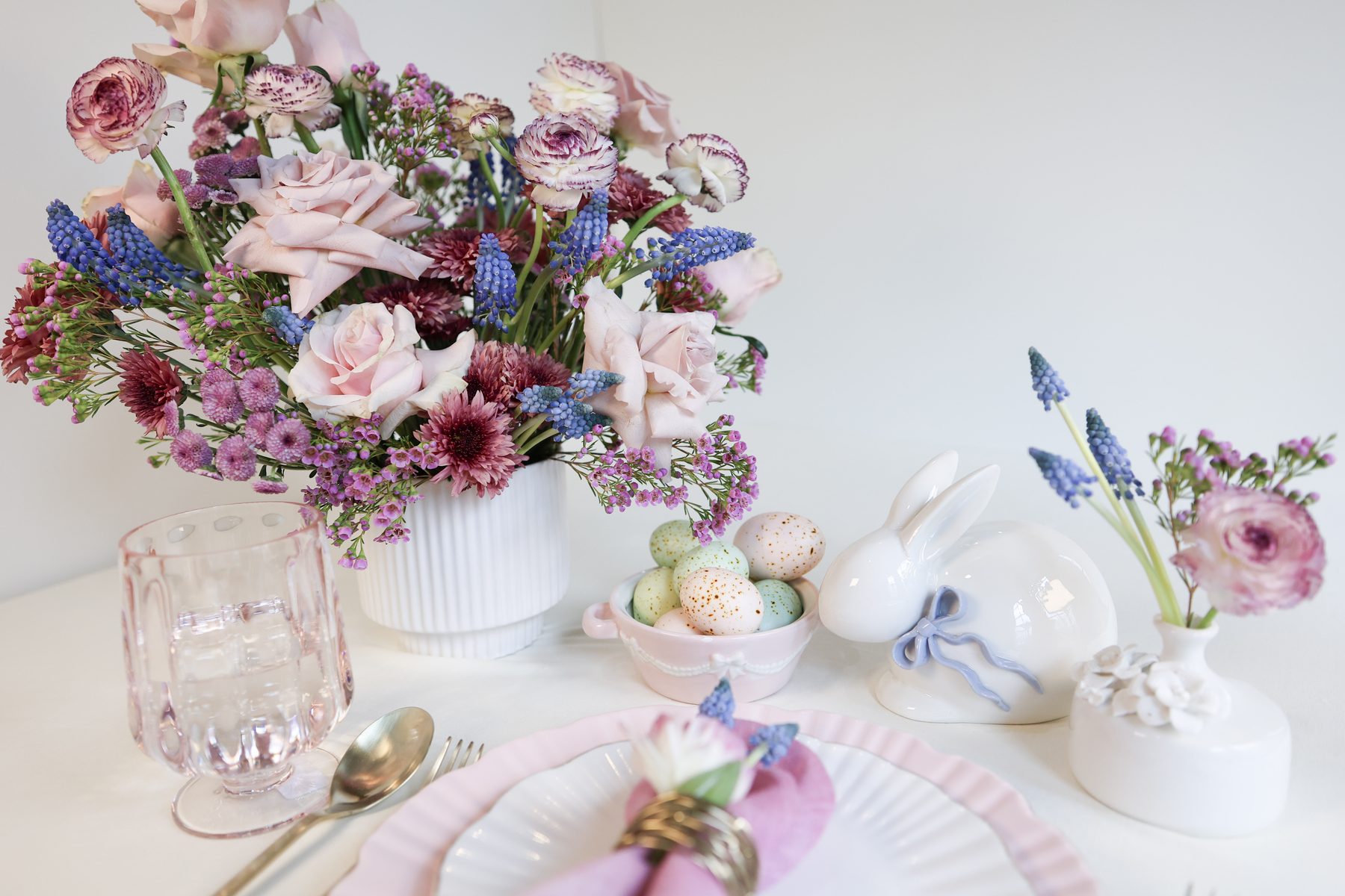 A vertical shot of a seasonal pastel centerpiece with delicate greenery.